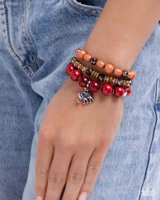 Stack of colorful beaded bracelets on a wrist with a denim background