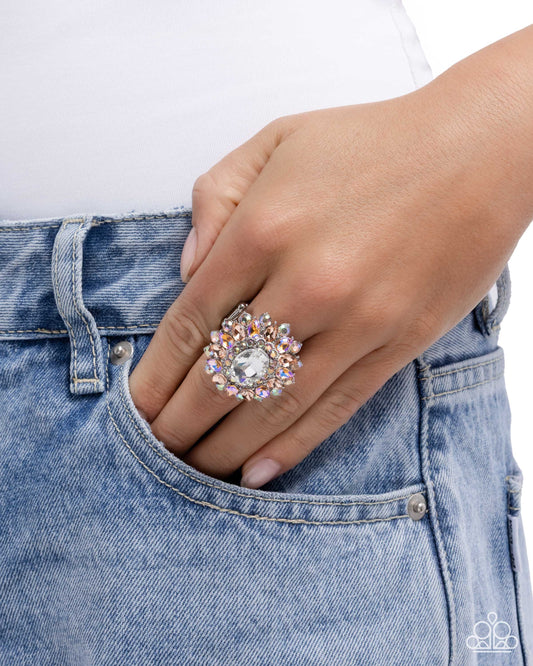 Hand wearing a decorative ring with blue jeans on a white background