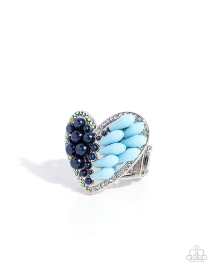 Heart-shaped ring with blue and black beads on a white background