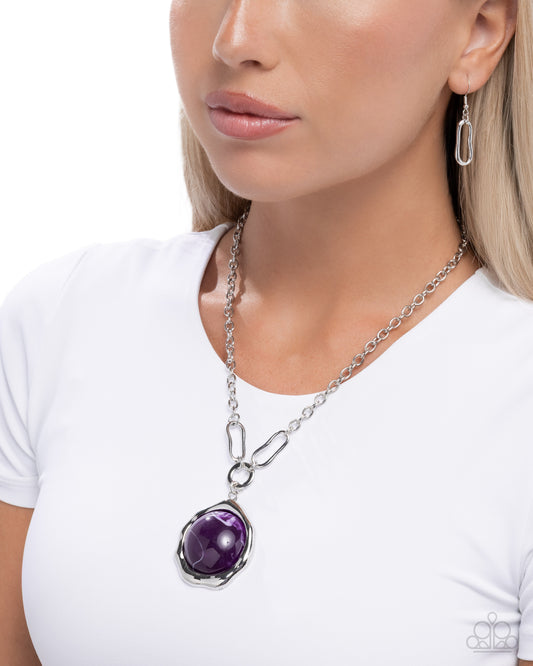 Woman wearing a silver necklace with a purple pendant on a white background