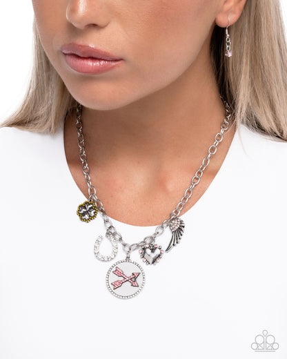 Necklace with various charms worn by a person on a white background