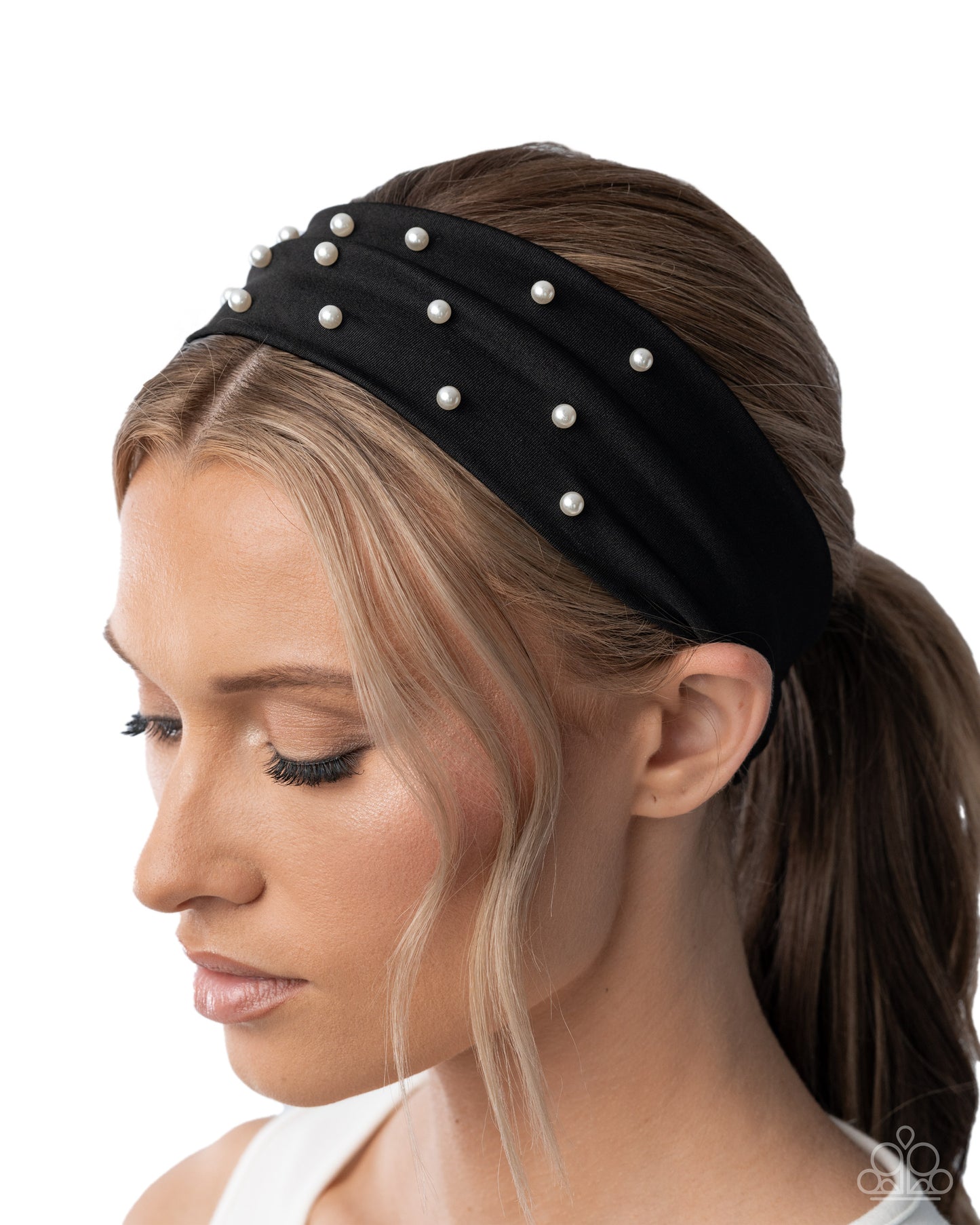 Woman wearing a black headband with pearls on a white background