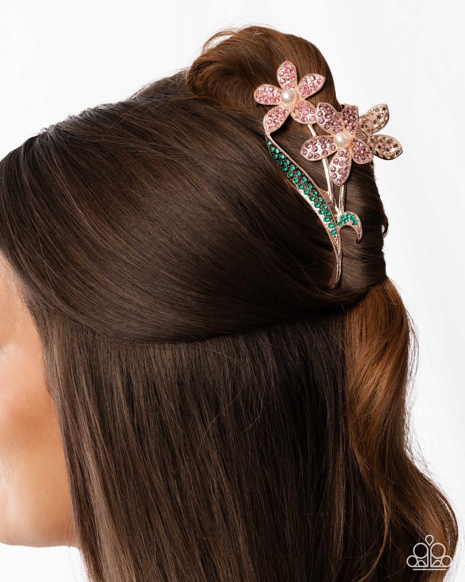 Mannequin head with brown hair styled with a decorative hair accessory featuring pink flowers and green accents.