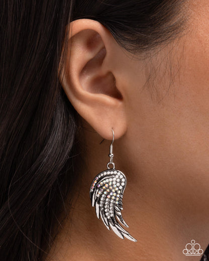 Silver wing-shaped earring worn by a person with dark hair.
