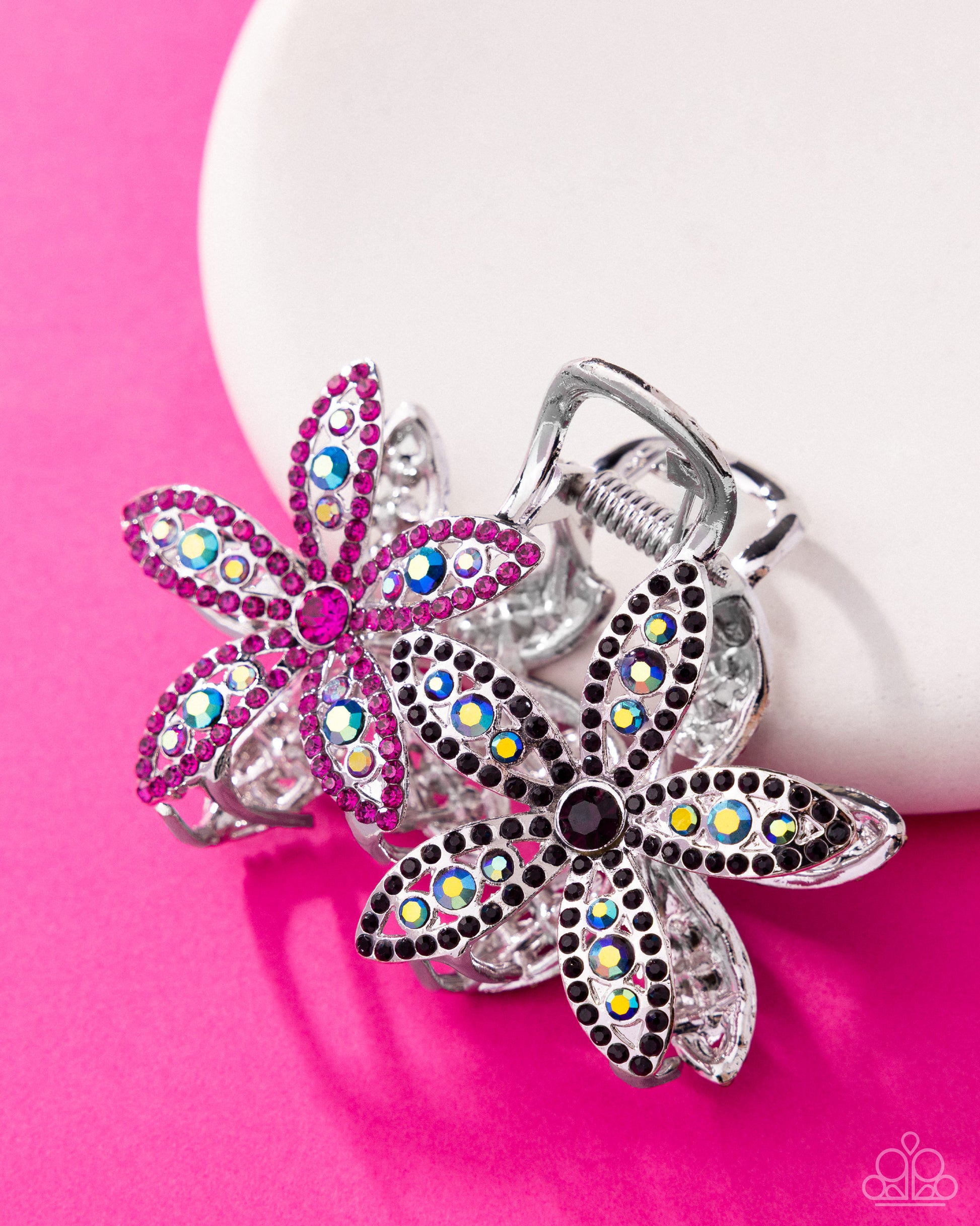Decorative keychains with floral designs and colorful gemstones on a pink background