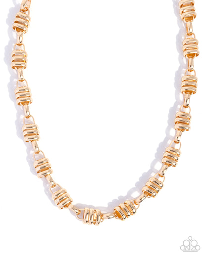 Gold beaded necklace on a white background