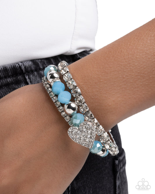 Bracelet with blue beads and silver accents on a wrist against a white background