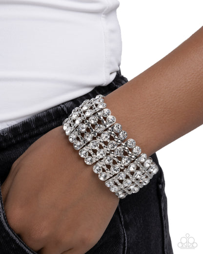 Silver bracelet on a wrist with a white background