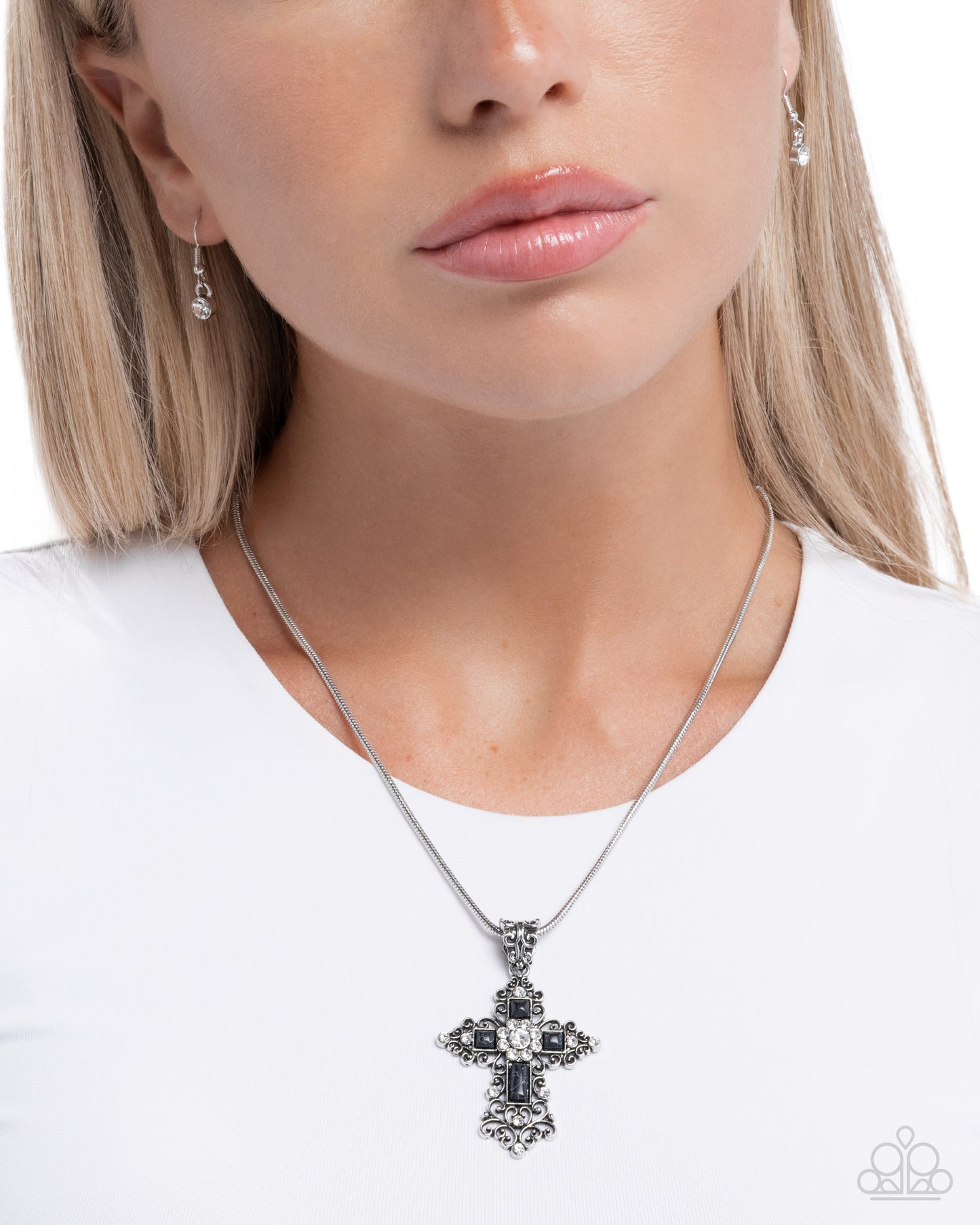 Woman wearing a silver cross necklace on a white background
