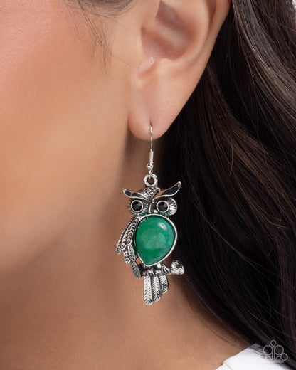 Silver owl earring with green gemstone worn by a model