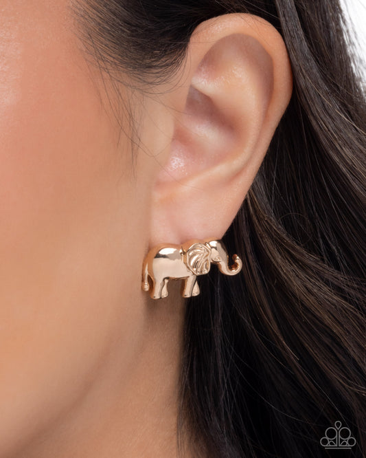 Gold elephant earring worn on an ear with dark hair.