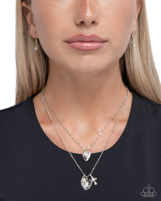 Woman wearing a silver necklace with star and moon pendant on a plain background