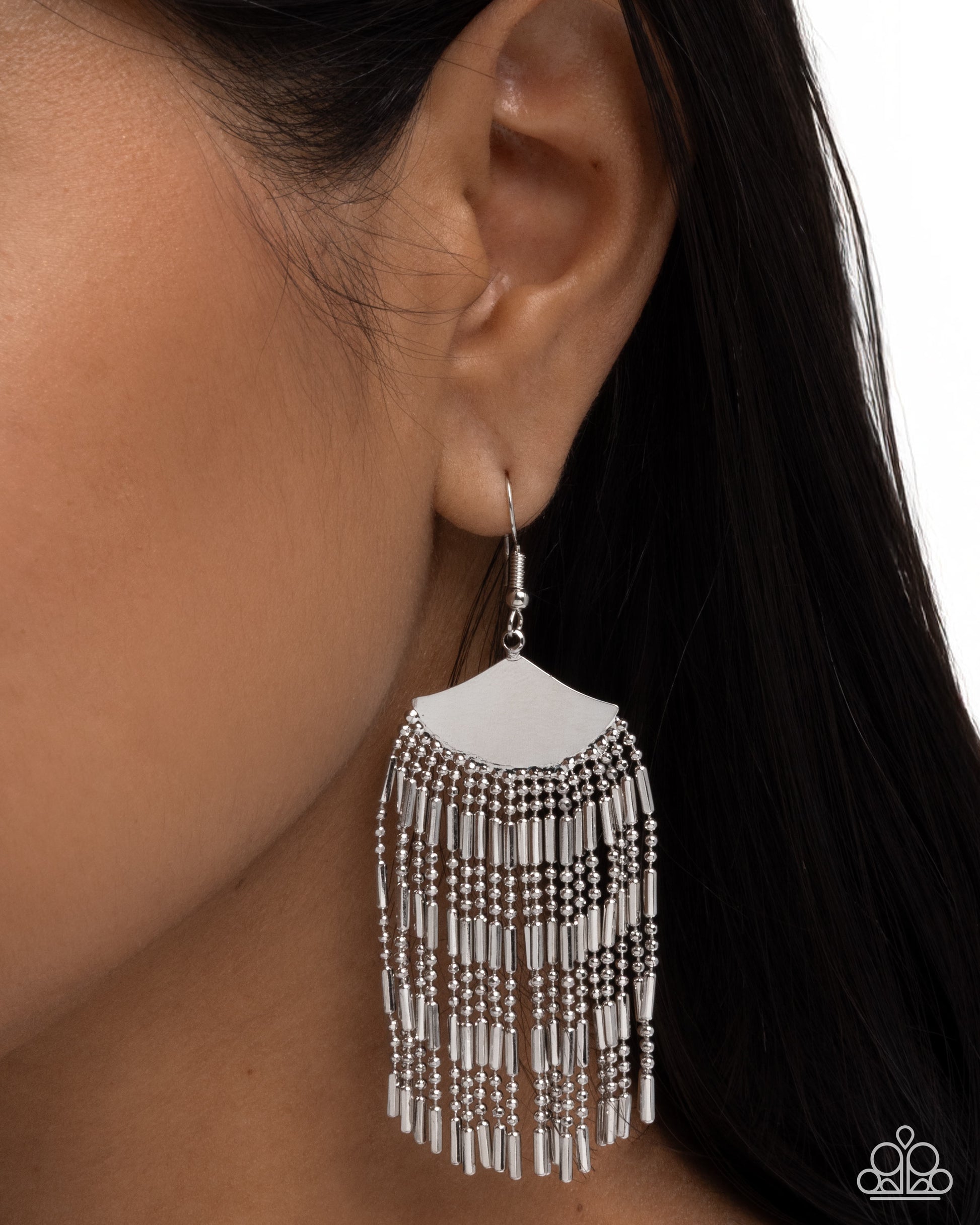 Close-up of an earring with a white and black beaded design on a blurred background
