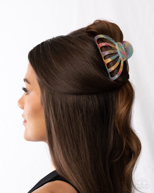 Woman with a colorful hair clip in her hair against a white background
