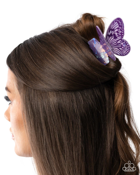 Purple butterfly hair clip on a woman's hair against a white background