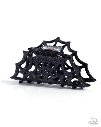 Black spiderweb-shaped hair clip on a white background