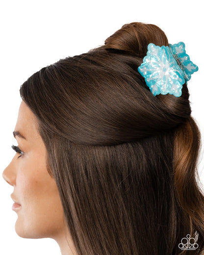 Blue hair clip in a person's hair on a white background