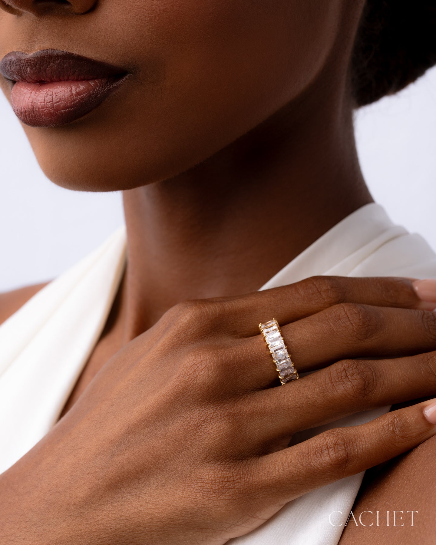 Close-up of a hand wearing a diamond ring with a blurred background