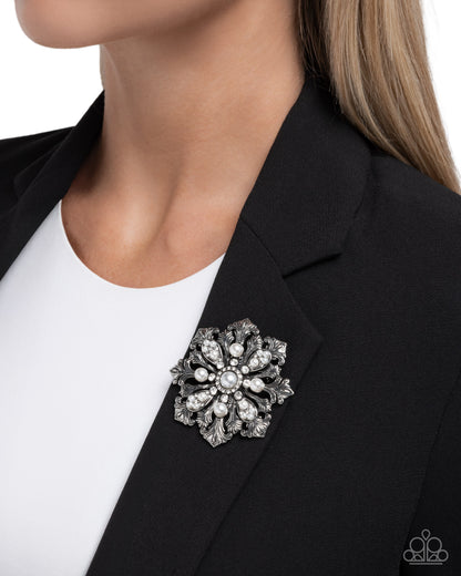 Jeweled brooch on a black blazer with a white shirt