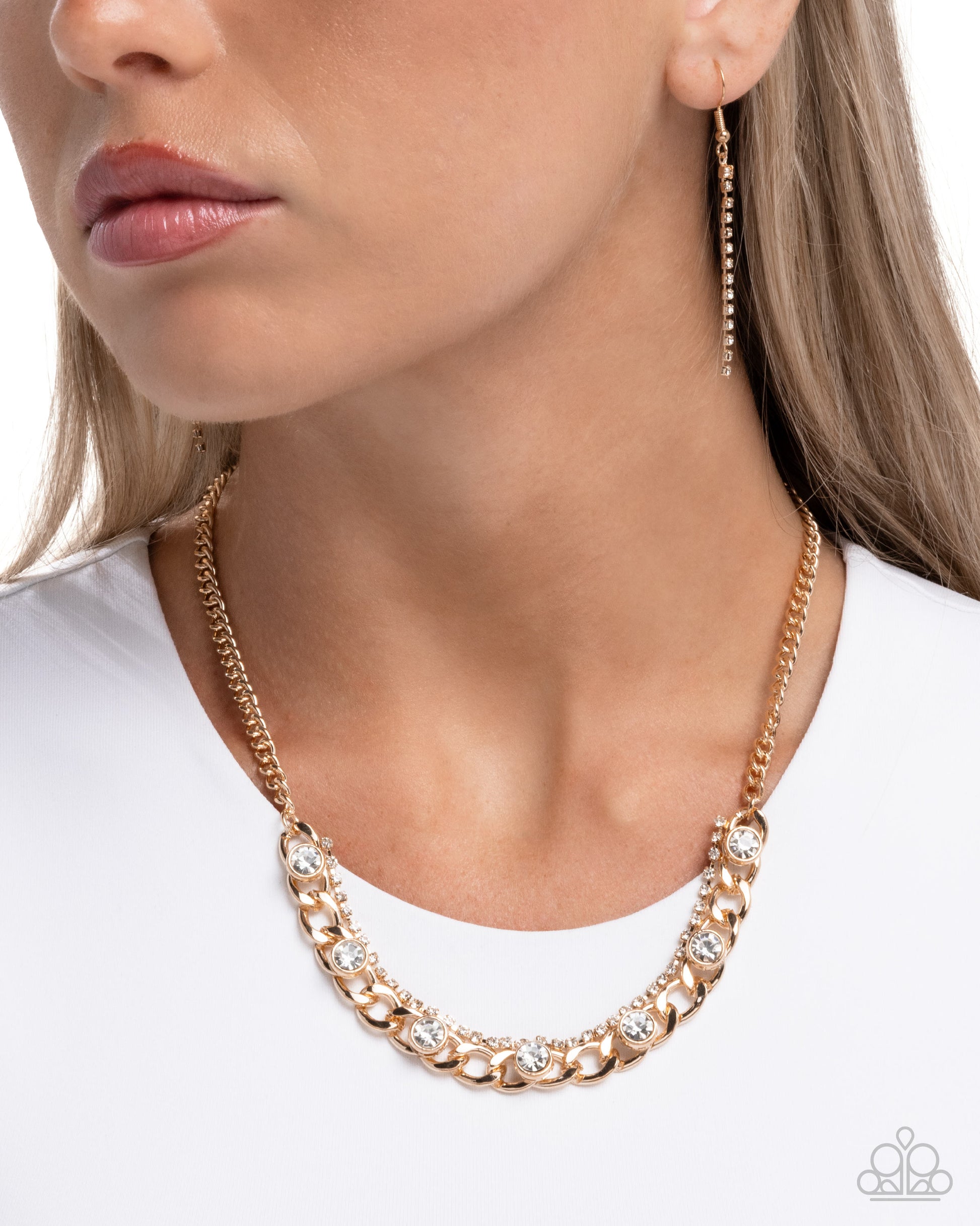 Gold chain necklace and earrings on a model against a white background