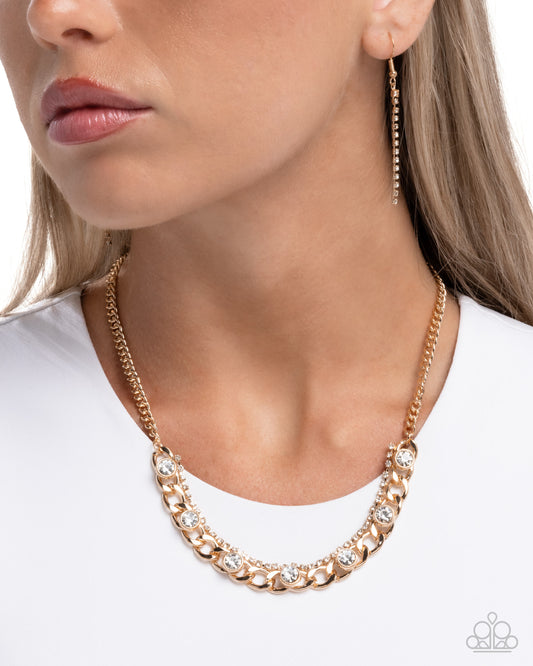 Gold chain necklace and earrings on a model against a white background