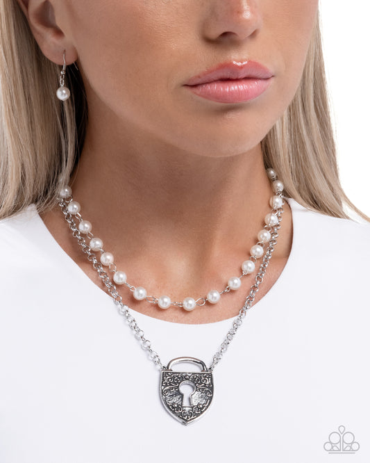 Pearl necklace with a silver lock pendant worn by a model on a white background