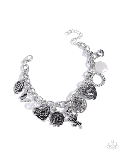 Silver charm bracelet with various charms on a white background