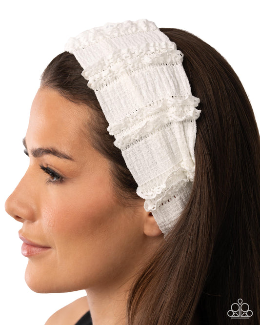 Woman wearing a white lace headband with a plain background