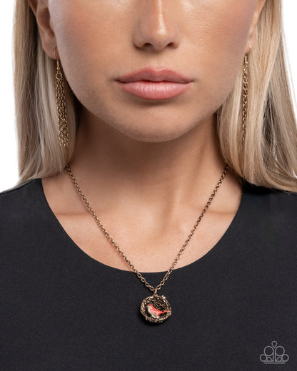 Close-up of a woman wearing a gold necklace with a pendant against a white background