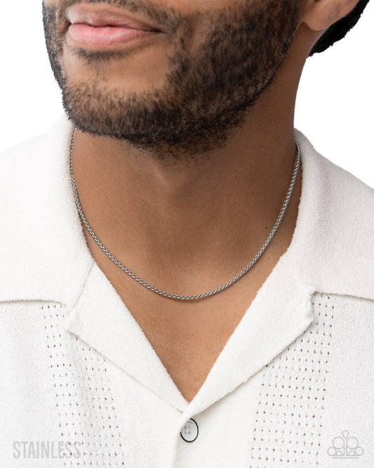 Man wearing a silver chain necklace on a white background