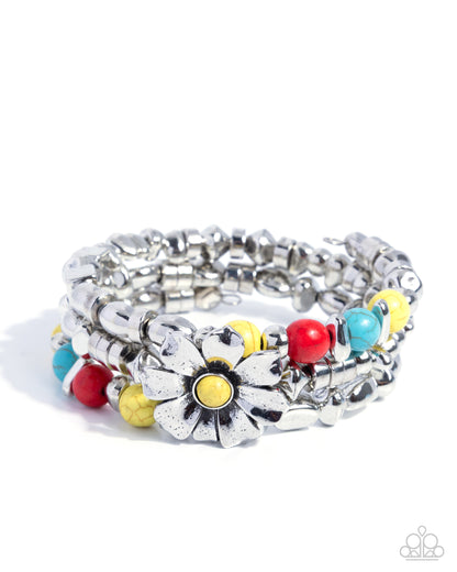 Stack of silver bracelets with colorful floral and round charms on a white background