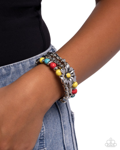 Bracelet with colorful beads on a wrist against a white background