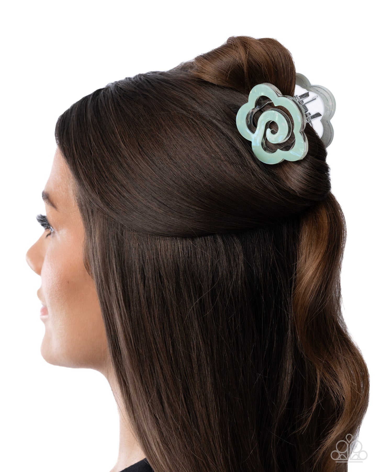 Woman with brown hair styled with a decorative hair clip on a white background