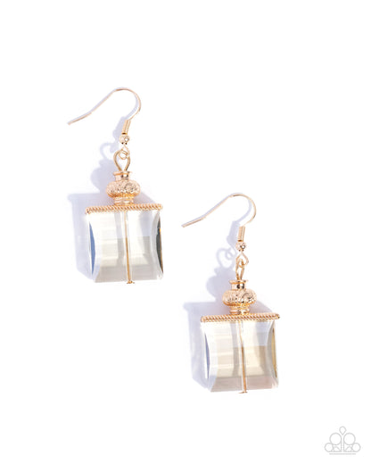 Pair of earrings with gold accents and clear stone on a white background