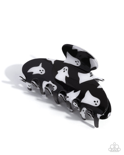 Black hair clip with white ghost designs on a white background