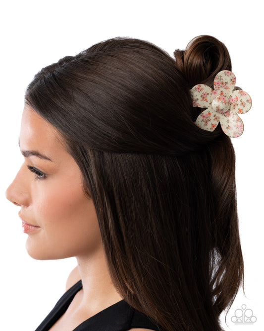 Woman with styled hair featuring a floral hair accessory on a white background