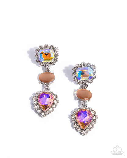 A pair of silver drop earrings featuring a square iridescent crystal, a peach oval stone, and a heart-shaped purple crystal, surrounded by clear rhinestones, on a white background.