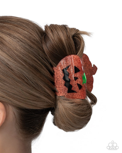 Hair bun with a decorative pumpkin clip on a white background