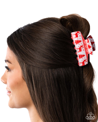 Woman with brown hair styled in a bun with a red and white hair clip featuring Christmas tree patterns.
