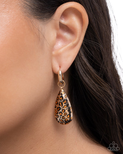 Leopard print teardrop earring worn by a model on a neutral background