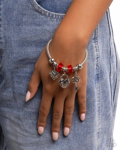 Bracelet with charms on a hand against a denim background