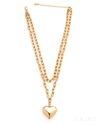 Gold chain necklace with a heart pendant on a white background