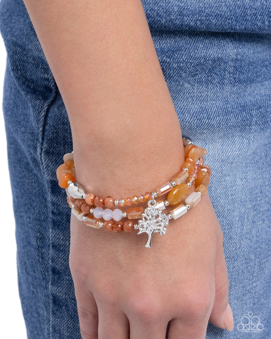 Stacked bracelets on a wrist with a denim background