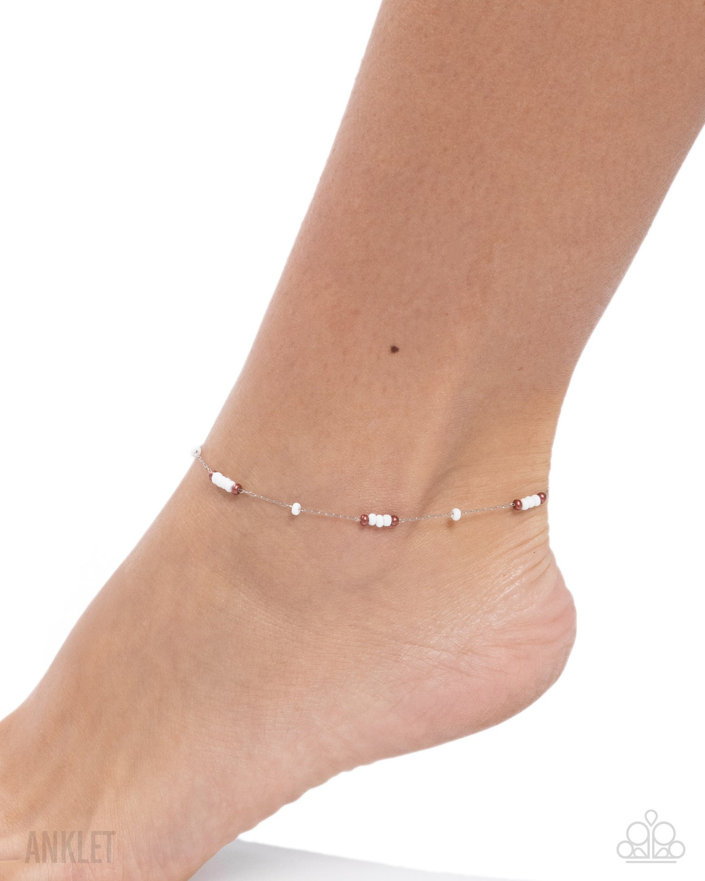 Ankle bracelet on a foot against a white background