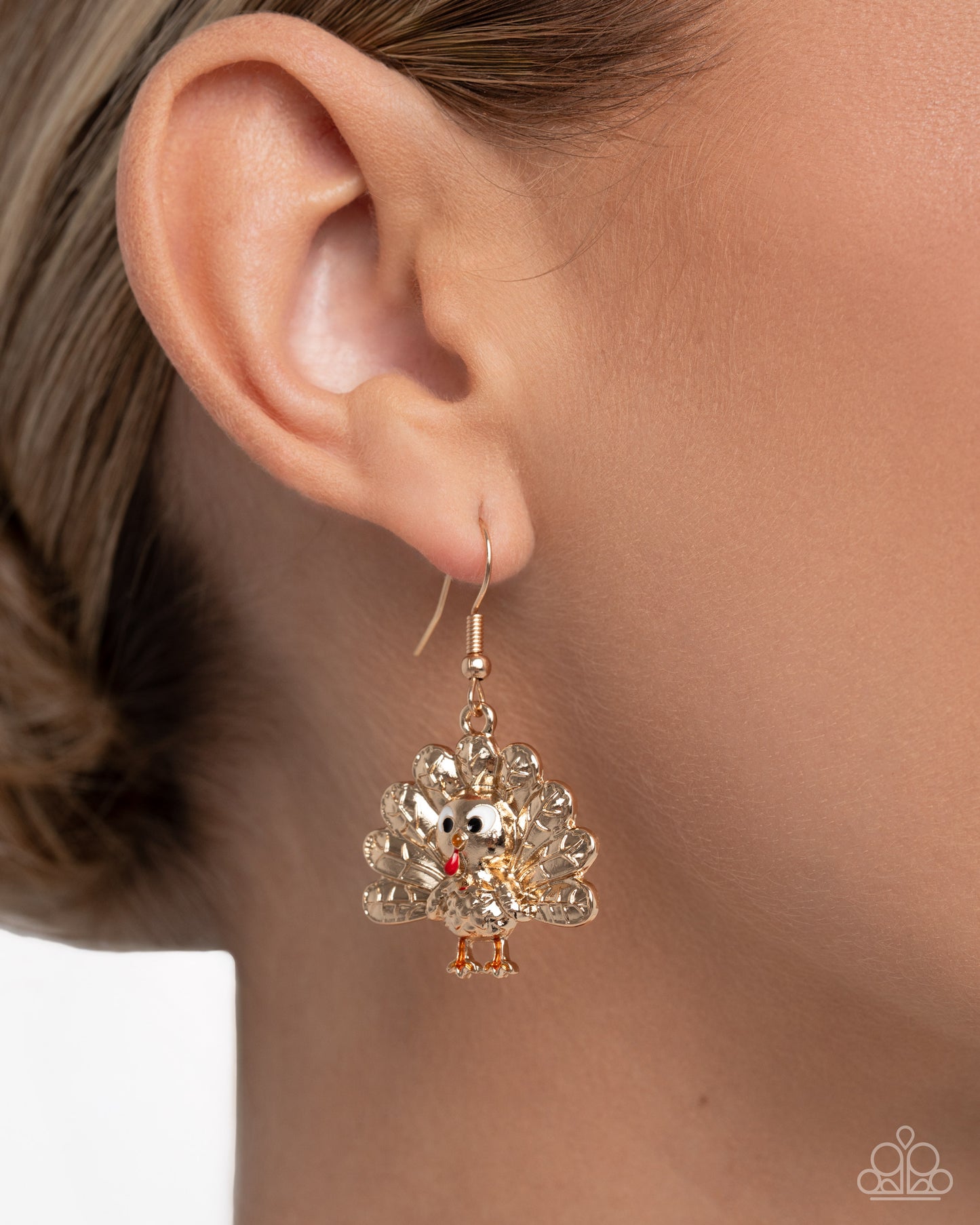 Earring worn on an ear with a plain background