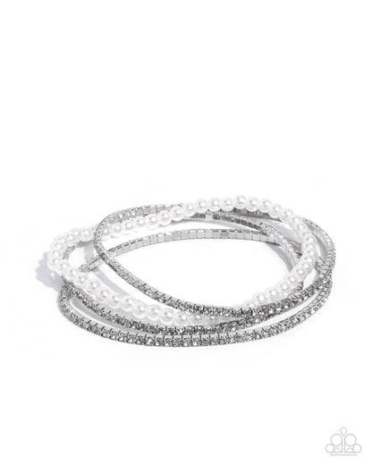 Set of three silver and white beaded bracelets on a white background