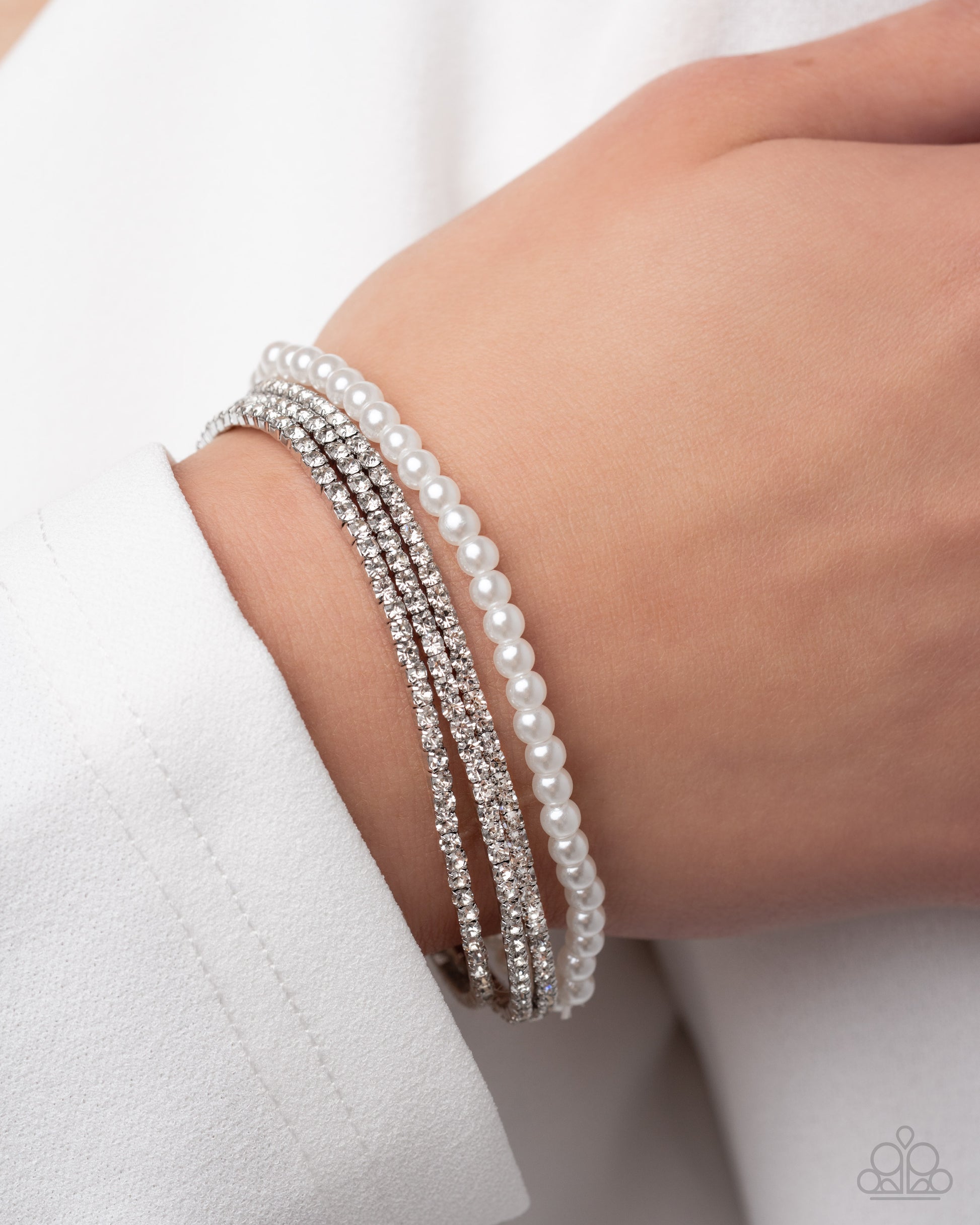 Stack of pearl bracelets on a wrist against a white background