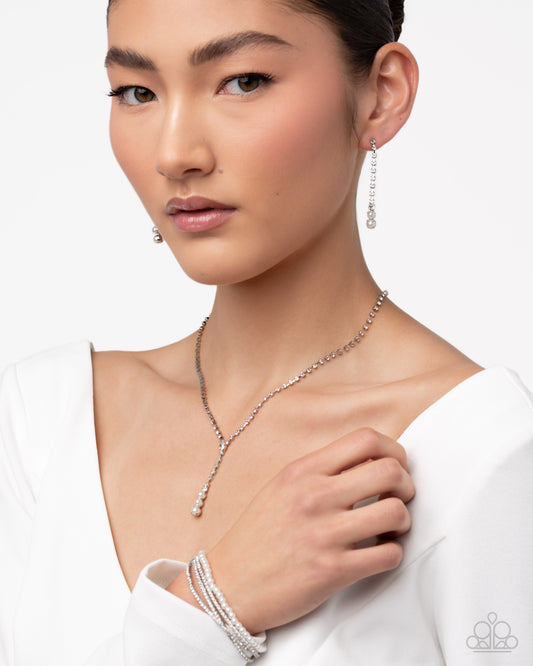 Woman wearing a silver necklace and earrings on a white background