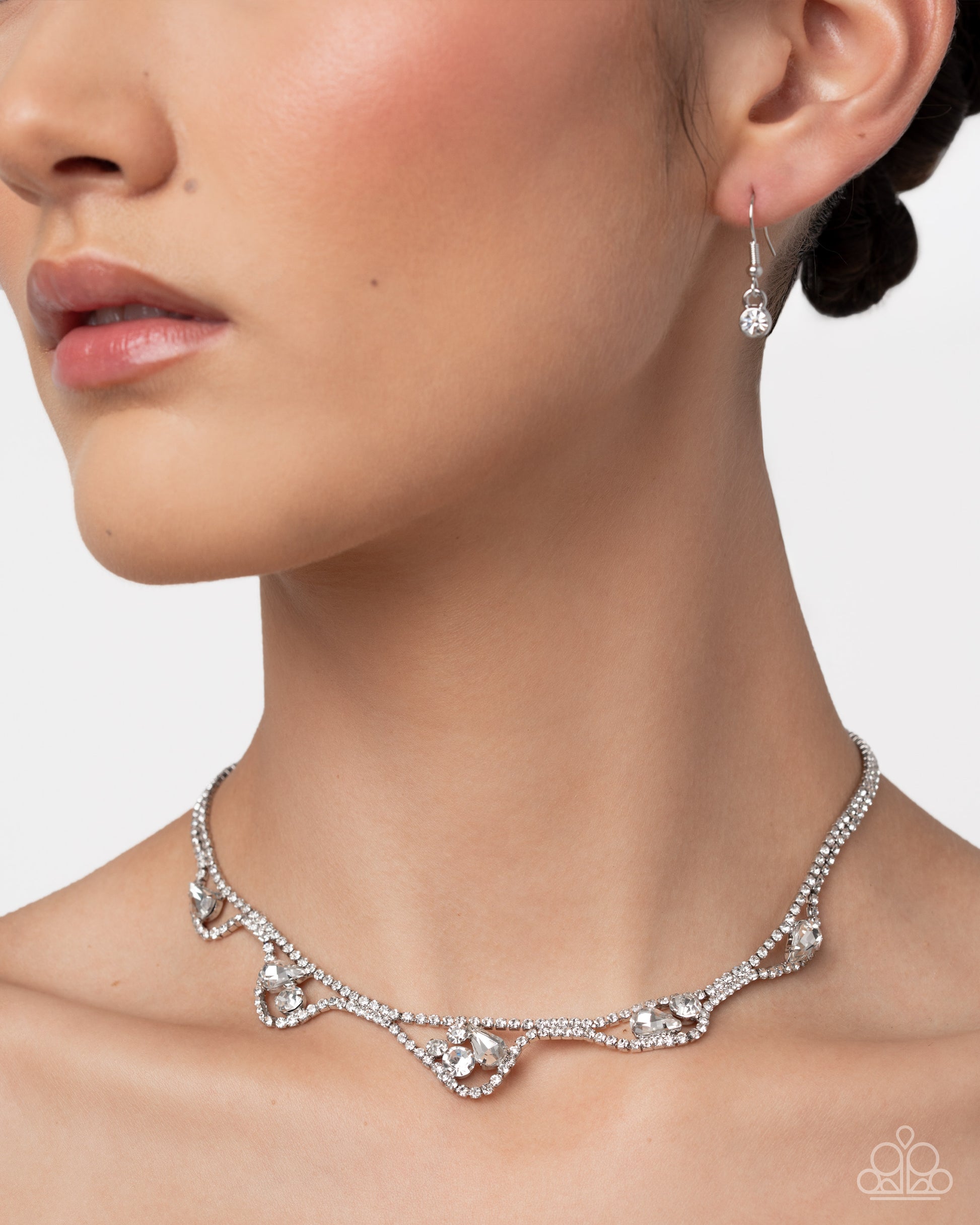 Necklace and earrings on a model with a neutral background
