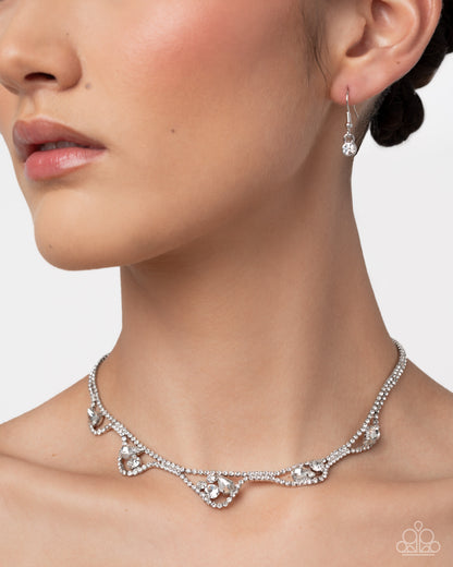 Necklace and earrings on a model with a neutral background